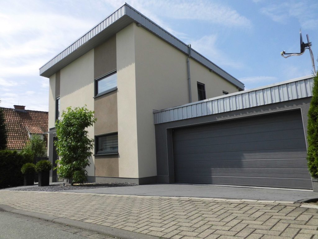 Modernes, schlichtes Wohnhaus mit heller und grauer verputzter Fassade