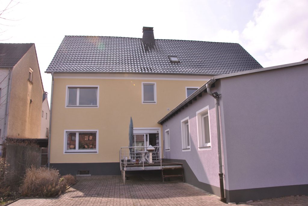 Sanierte Hausfassade in hellem Gelbton